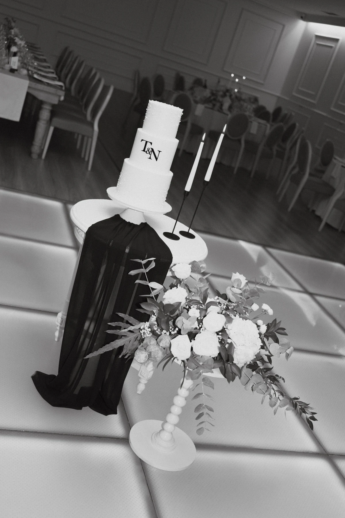 Detalhe de bolo de casamento durante uma celebração, a preto e branco